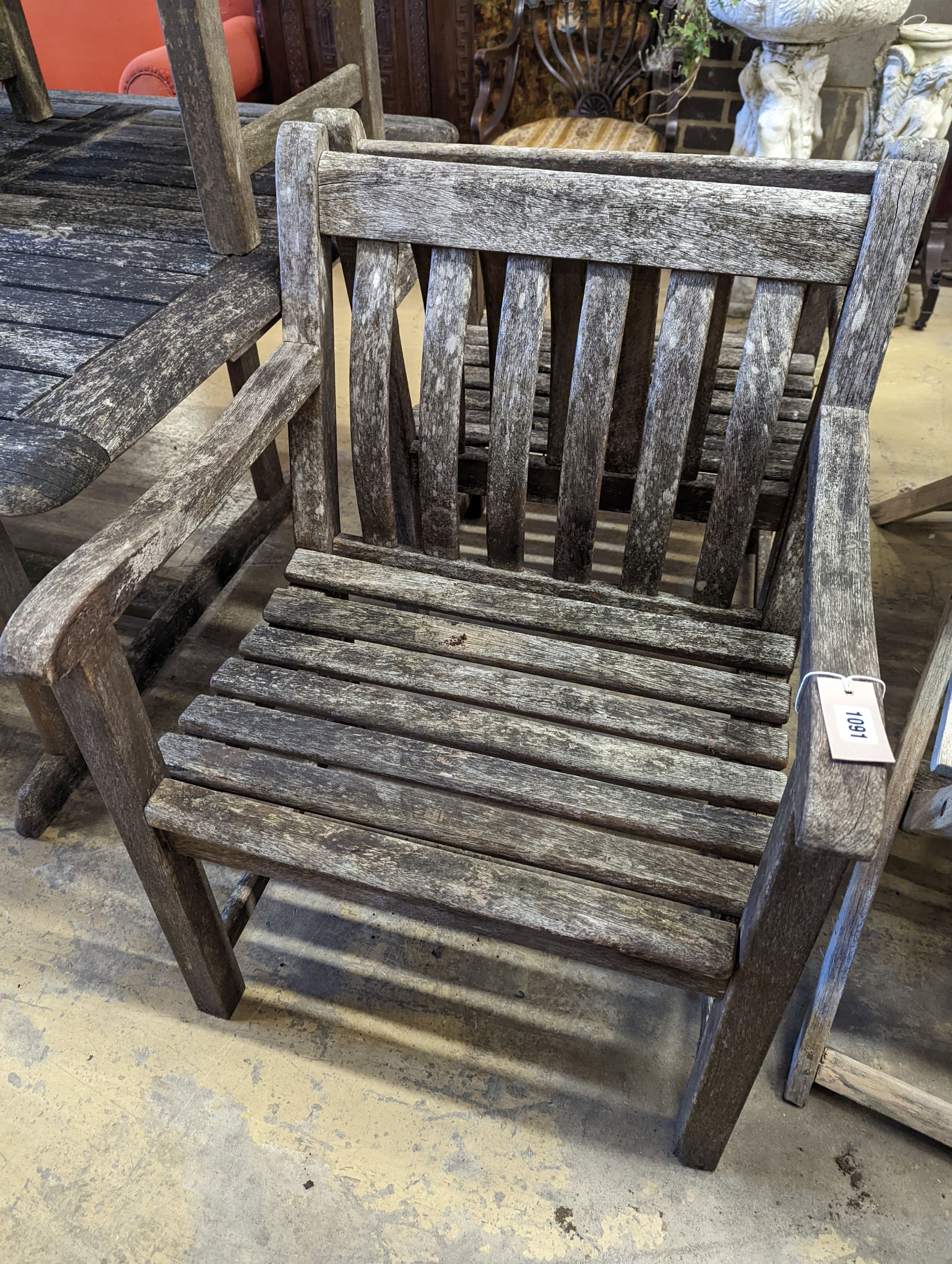 A rectangular weathered teak garden table, length 160cm, depth 110cm, height 73cm, six elbow chairs and a parasol